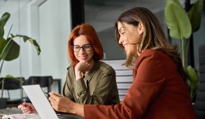 mujeres hablando de logíostica con un ordenador