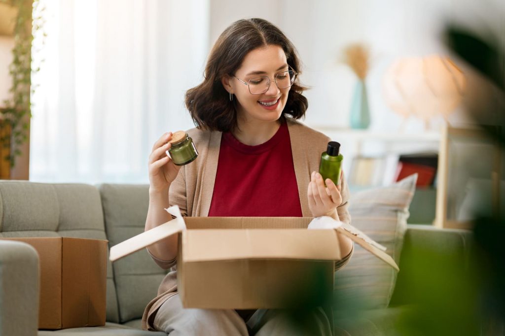 mujer abriendo caja con cosméticos